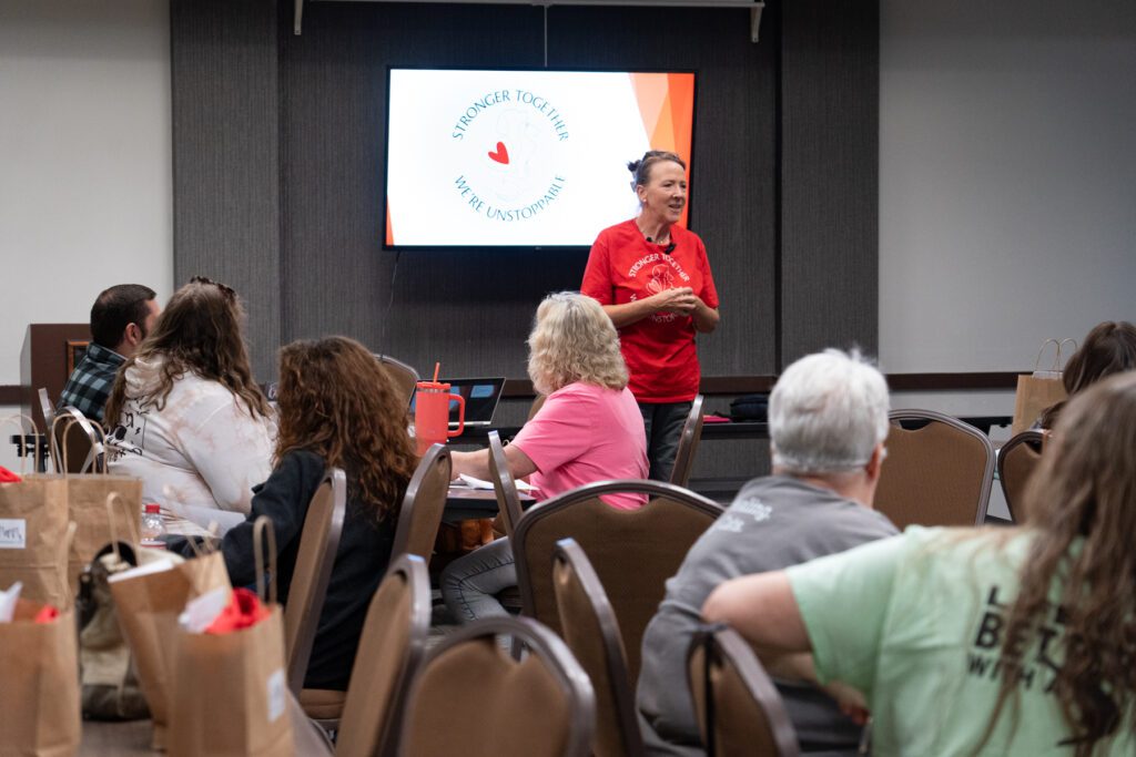 group of rescue and shelter volunteers and staff listen to Cara Achterberg talk about the animal crisis
